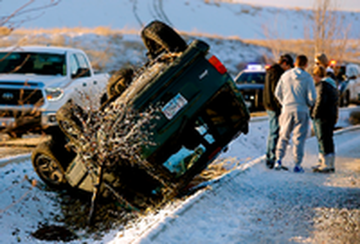 A Jeep Cherokee rests of its roof in the ditch between lanes on the Bob Olson Parkway Wednesday after the 17-year-old driver lost control on the icy roadway, said Kennewick police.