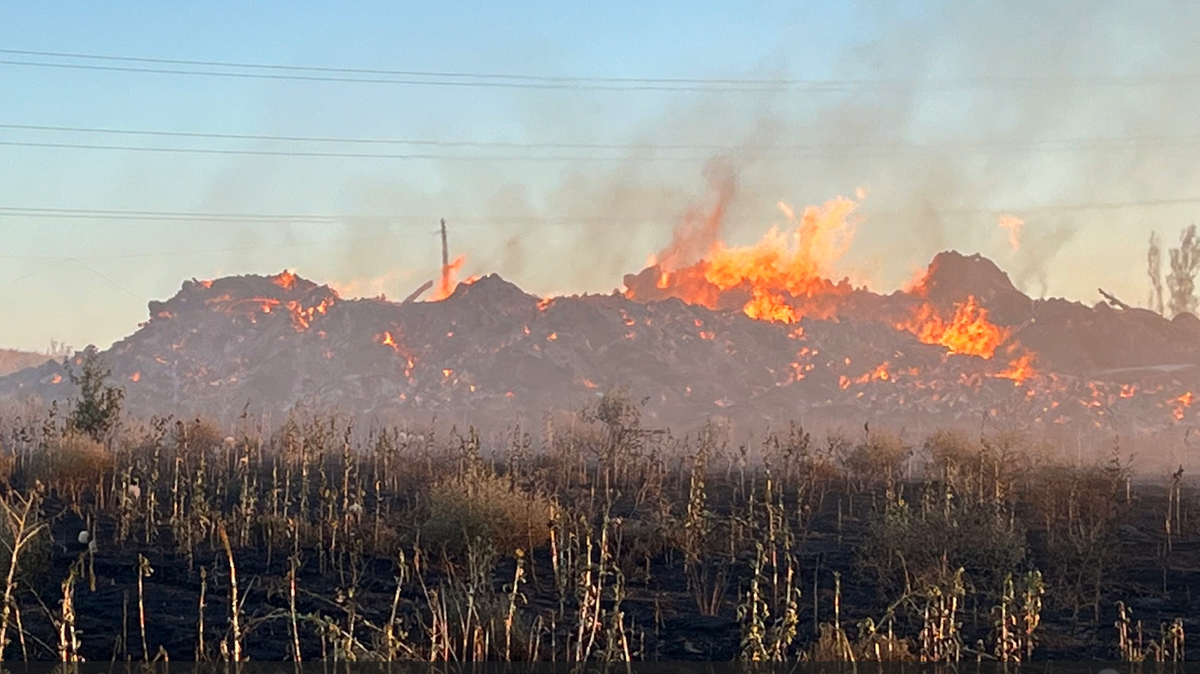 A fire contained to a slash pile of tumbleweeds and other vegetation cleared for a south Kennewick construction project may burn for days, say fire officials.