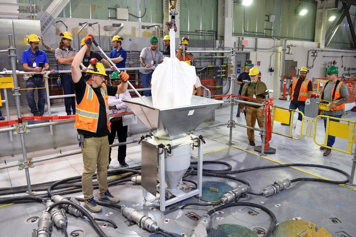 Workers at the Hanford site vitrification plant add frit, or glass beads, to the first melter inside theLow-Activity Waste Facility as preparations are made to glassify radioactive waste.