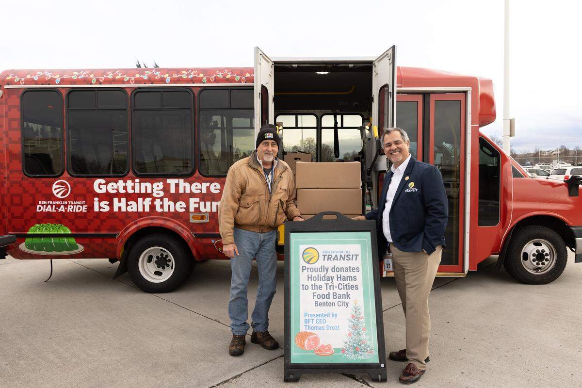 Ben Franklin Transit CEO Thomas Drozt, right, donates 57 holiday hams to the Tri-City Food Bank.