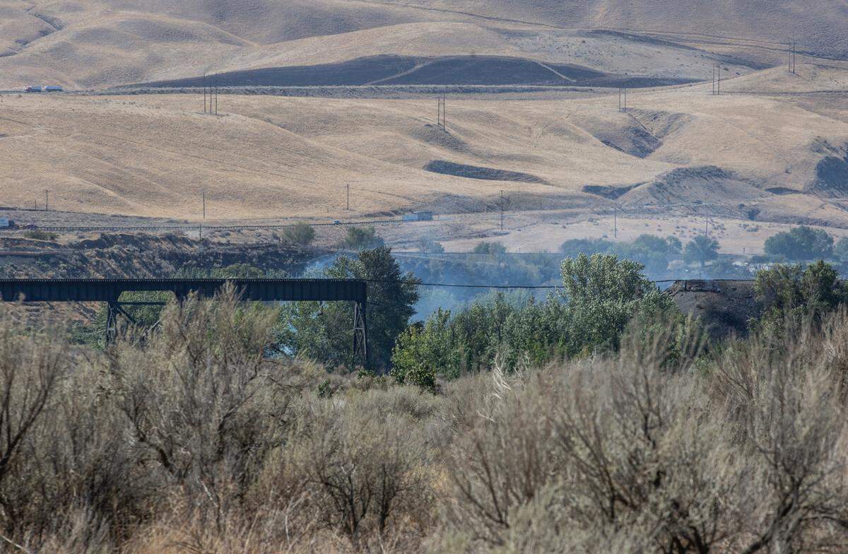 A train trestle over the Yakima River near Whitstrand burned Monday night and was still smoldering Tuesday morning.