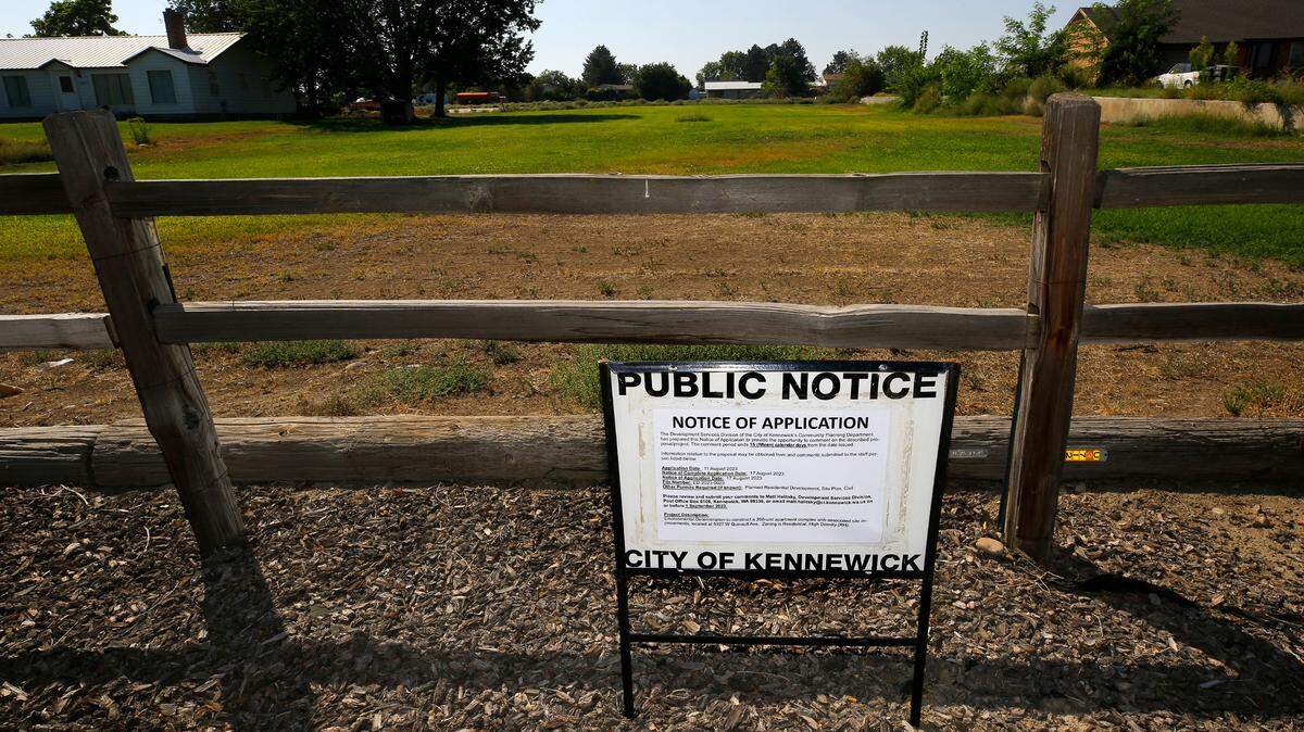 A sign from the city of Kennewick’s planning department seeks public input on the proposed Quinault Village.