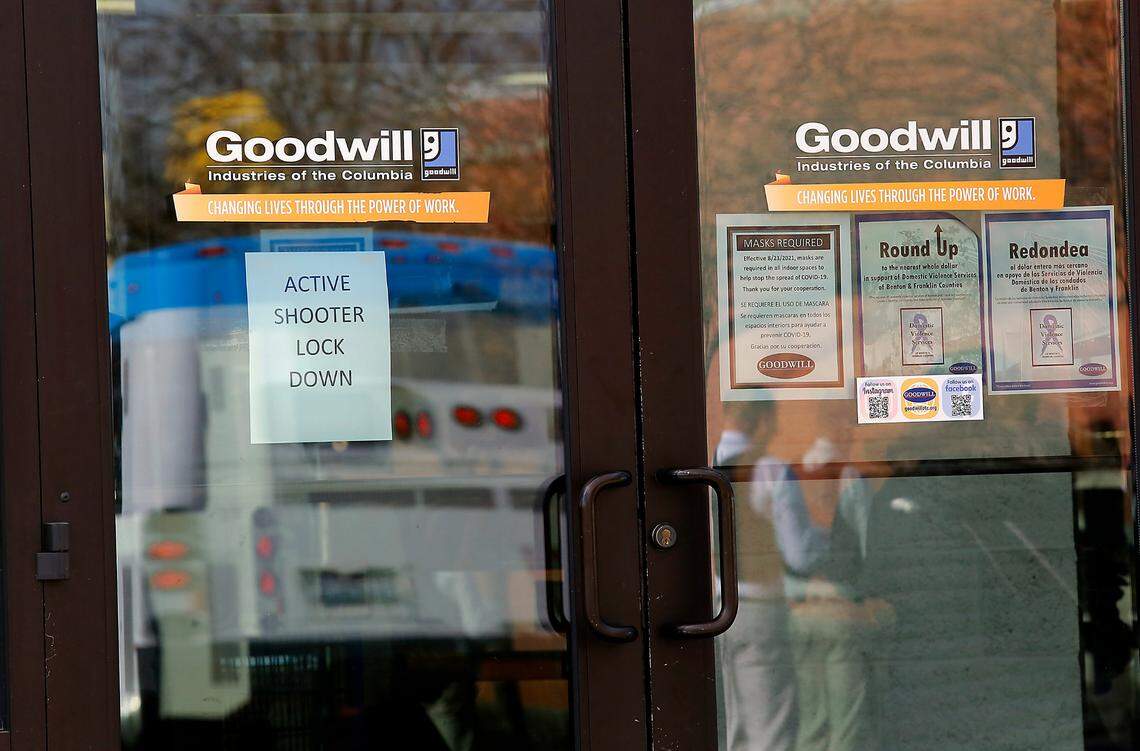 Signs on the nearby Goodwill Store warn of a lockdown, after one person was killed and at least one other wounded in a shooting inside the Richland, Wash., Fred Meyer store on Wellsian Way on Monday morning. Police are searching for a suspect.