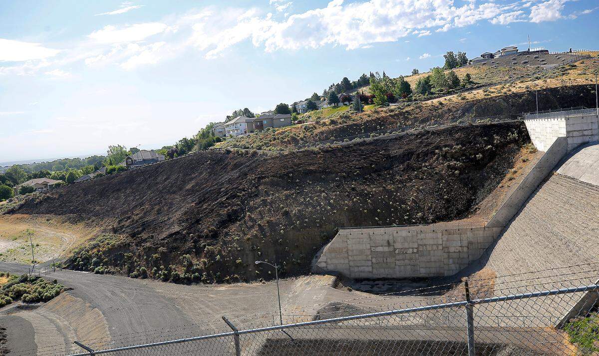 An early morning brush fire scorched an area near the Zintel Canyon Dam below South Union Street and West 42nd Avenue in Kennewick.