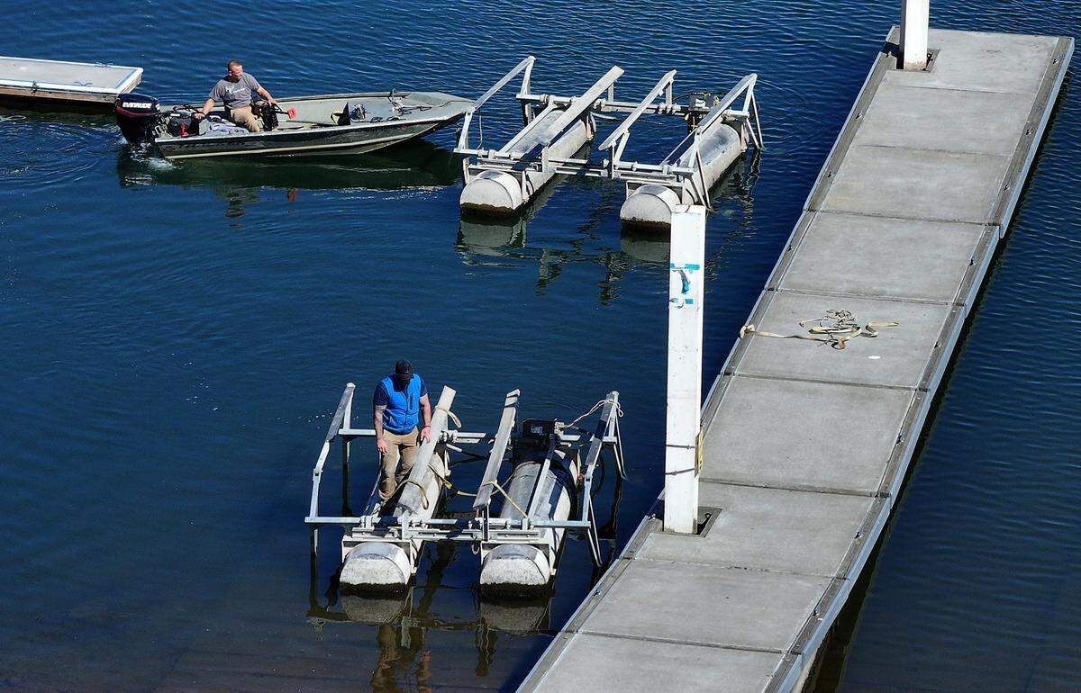 Workers line up boat lifts in a boat launch ramp next to the Columbia Park Marina for removal from the water while dismantling the boat docks at the facility in the west end of Columbia Park in Richland.