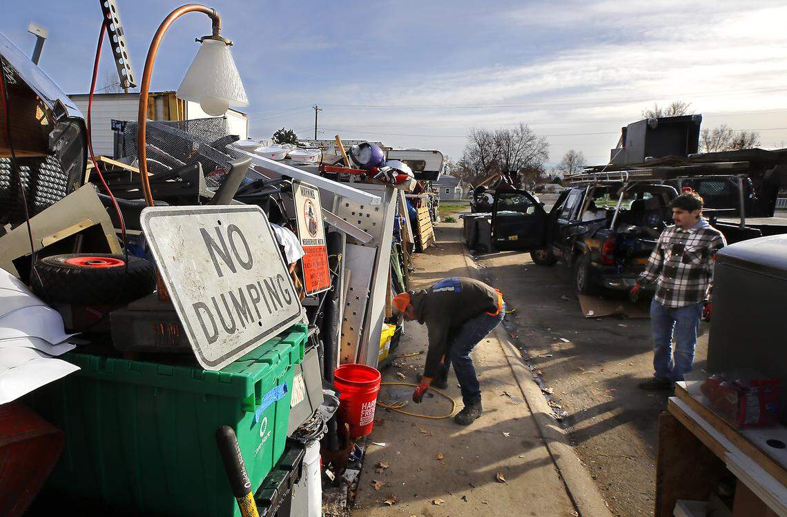 A contractor and his employee, hired by the city of Richland, remove items March 7 from the right of way in front of 2100 Pullen St. in Richland.