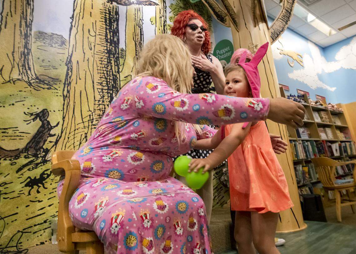 Four-year-old Harper Lonigan, right, hugs Sugar, left, after Drag Queen Story Time at Barnes & Noble in Kennewick on Saturday. Hundred of people attended the event.