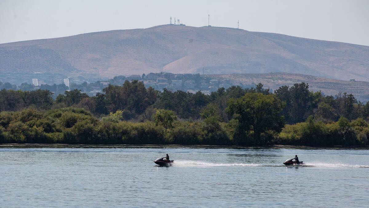 A pair of jet skis zips down the Columbia River near Chiawana Park in Pasco.