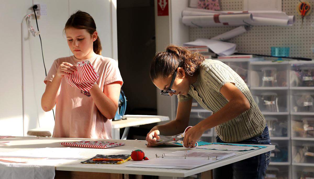 Jessica's Sewing School students Maisie Nolte, 10, left, and Lucca Taranto, 15, work on their current sewing class project at the Kennewick business.