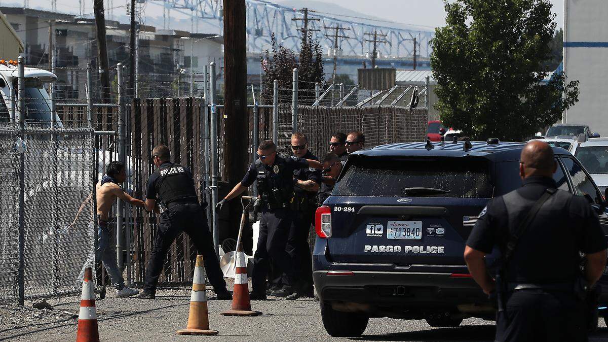 A shirtless man involved in a nearly one hour long standoff with Pasco police surrenders to officers after walking out of the gate of the fenced impound lot for Casaday Bee-Line Towing at 1716 W. Lewis St. in Pasco.
