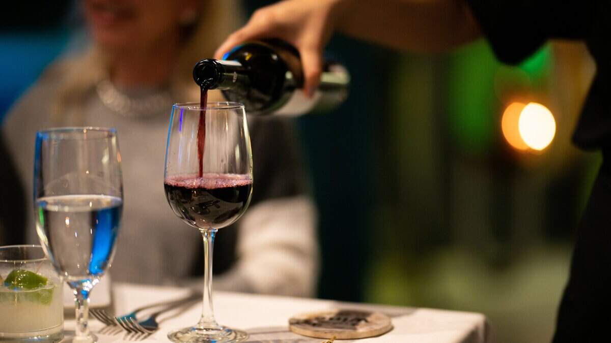 AUSTIN, TEXAS - APRIL 05: A waitress pours a glass of wine for guests at the It's Italian Cucina restaurant on April 05, 2023 in Austin, Texas. A new analysis of more than 40 years of accumulated research has found that moderate drinking has no health benefits. (Photo by Brandon Bell/Getty Images)