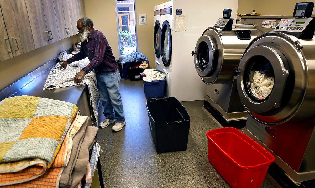 Jacob Braziel folds blankets and bed linens in the laundry facility at the Tri-City Union Gospel Mission on a recent frigid winter day. Braziel is a participant in the New Life program at the mission.