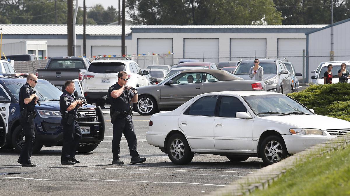 Officers from the Richland and Kennewick Police Departments cautiously approach a four-door Toyota sedan after following the car from Highway 240 into a Kennewick convenience parking lot on North Edison Street. The female driver had already been detained and nobody else was found inside. The female was free to leave the scene but the car was towed away, accoding to police officials.