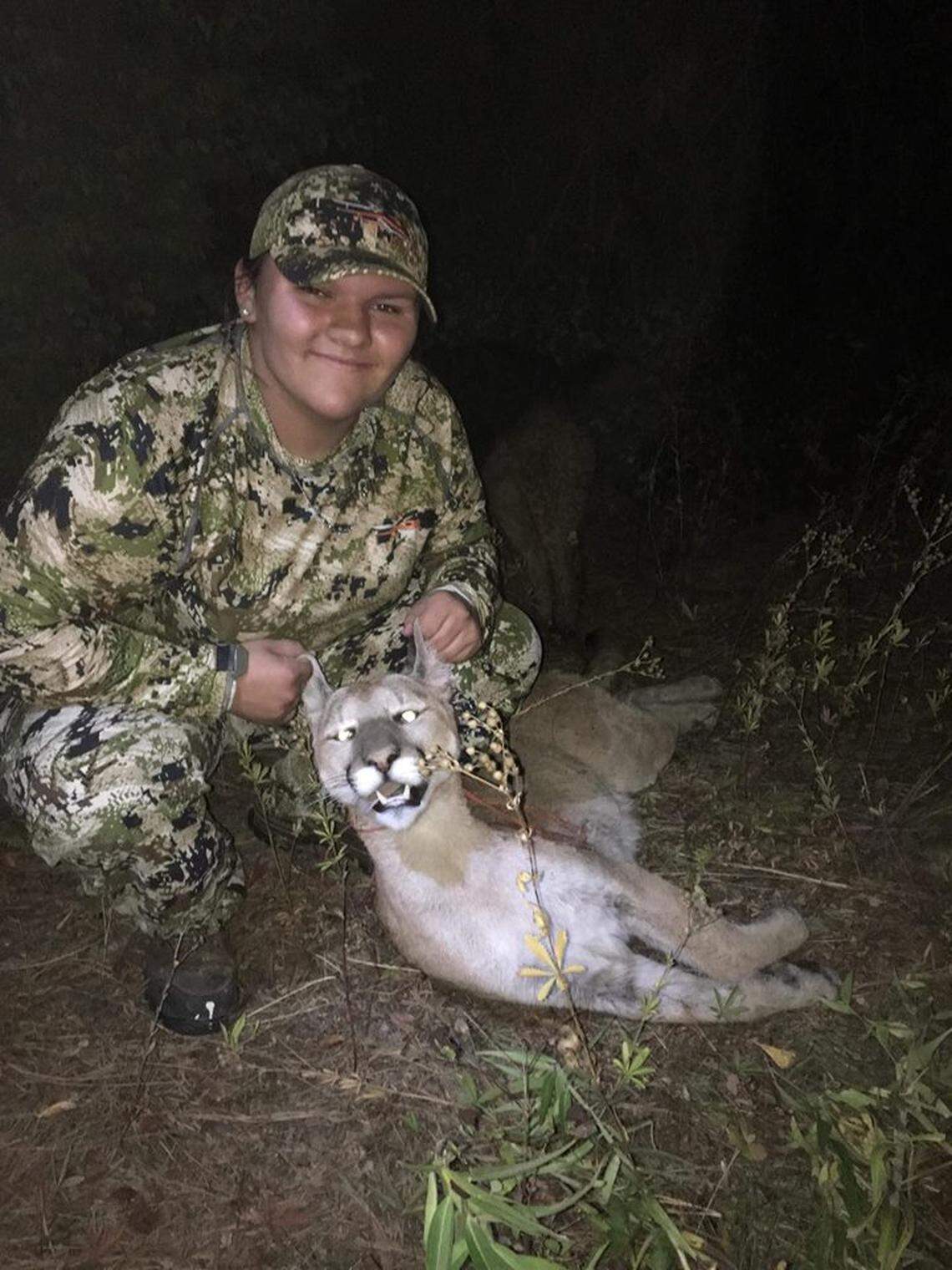 Amaya Simpson poses with the cougar she shot with her bow and arrow after it threatened her brother Cole Seymour near their home on the Colville Indian Reservation.