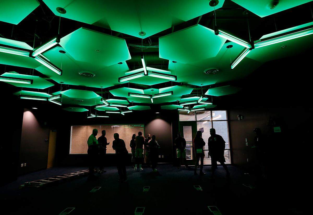 Visitors touring the new 80,000-square-foot student recreation center at Columbia Basin College in Pasco walk through the ESports gaming center that features specialized lighting for competitions.