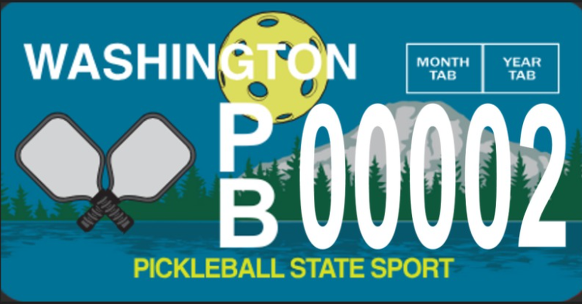 Early designs for the Pickleball State Sport special design license plate showcase a blue background with green trees and Mount Rainier in the distance, a yellow pickleball and two paddles.