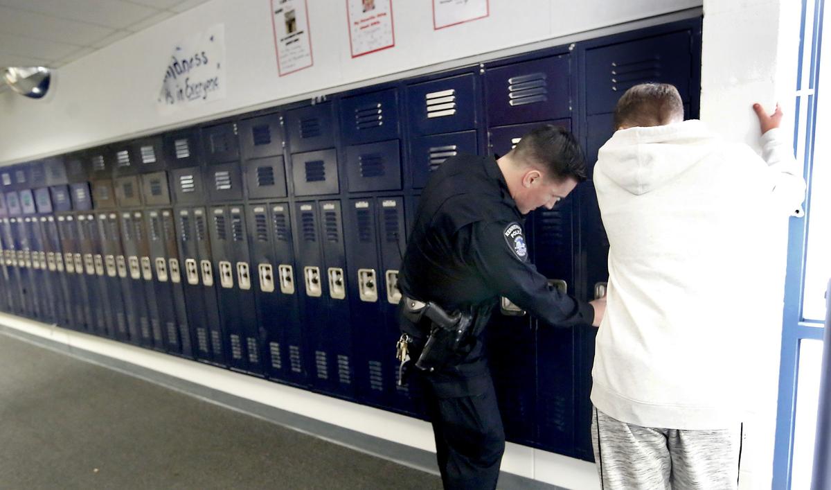 School Resource Officer Tim Harris, of the Kennewick Police Department, helps student Dylan Lettrick open his jammed hallway locker recently at Highlands Middle School in Kennewick. Watch a video at: tricityherald.com/video