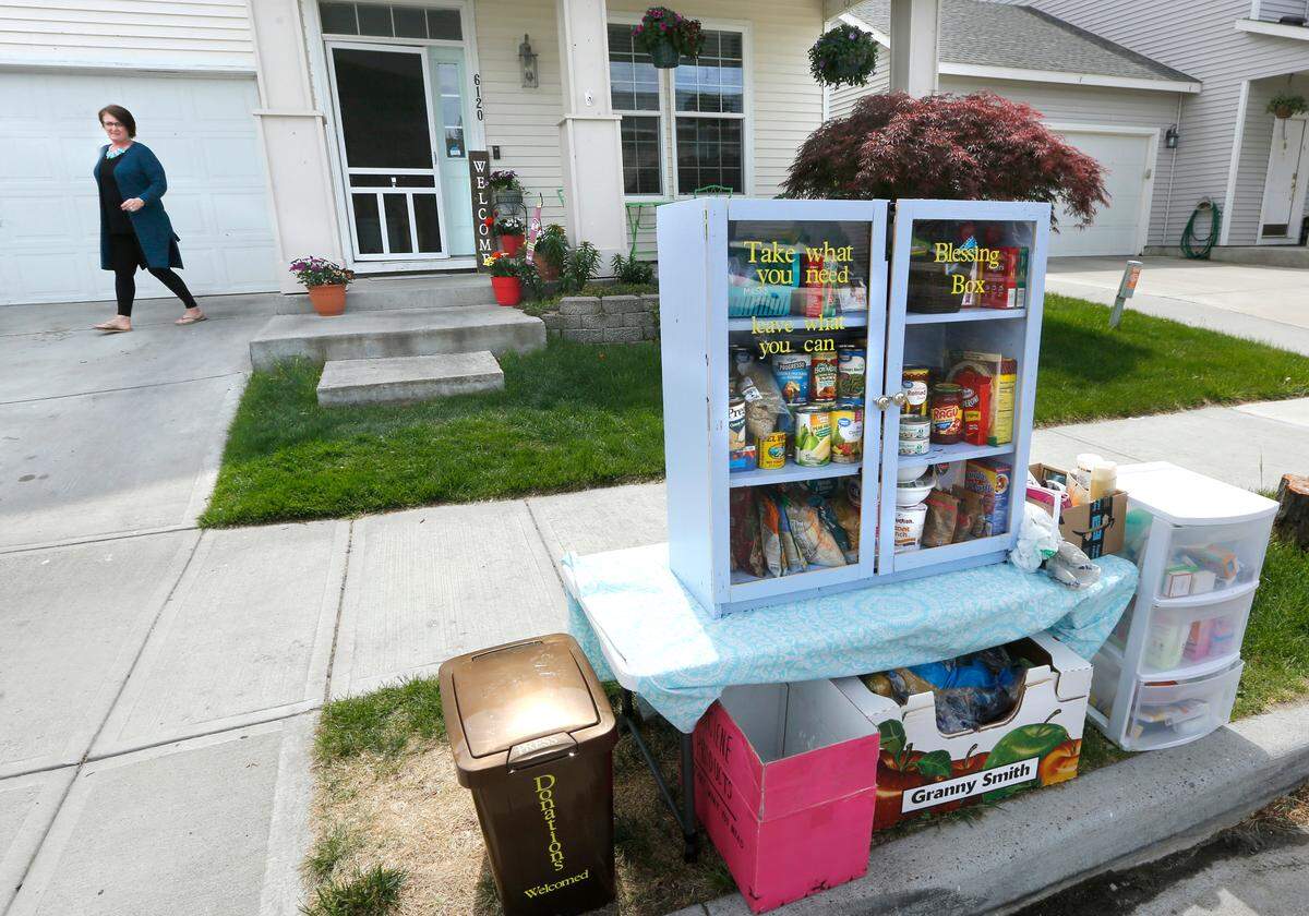 Angie Martin of Pasco walks toward the Blessing Box her daughter, Paige, 25, suggested they create to help neighbors in need during the coronavirus pandemic. The food pantry, similar in concept to a “little library,” has grown in popularity in the neighborhood. Watch a video at: tricityherald.com/video