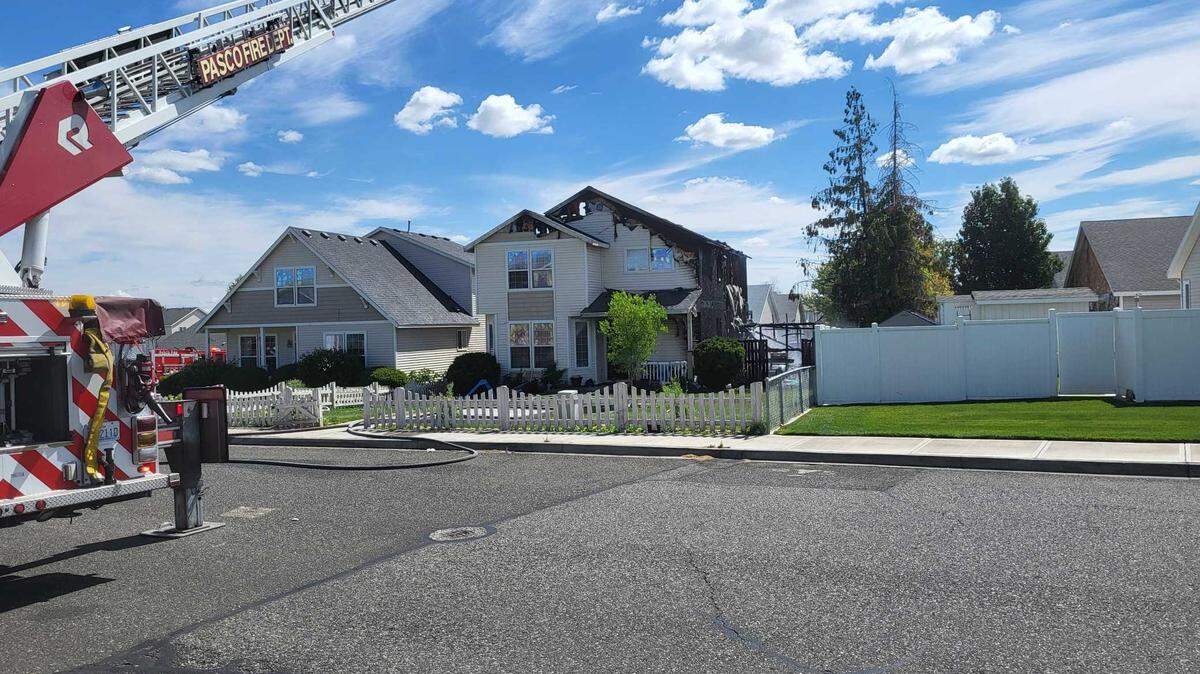 A two-story home in west Pasco was heavily damaged when fire spread from a backyard barbecue.