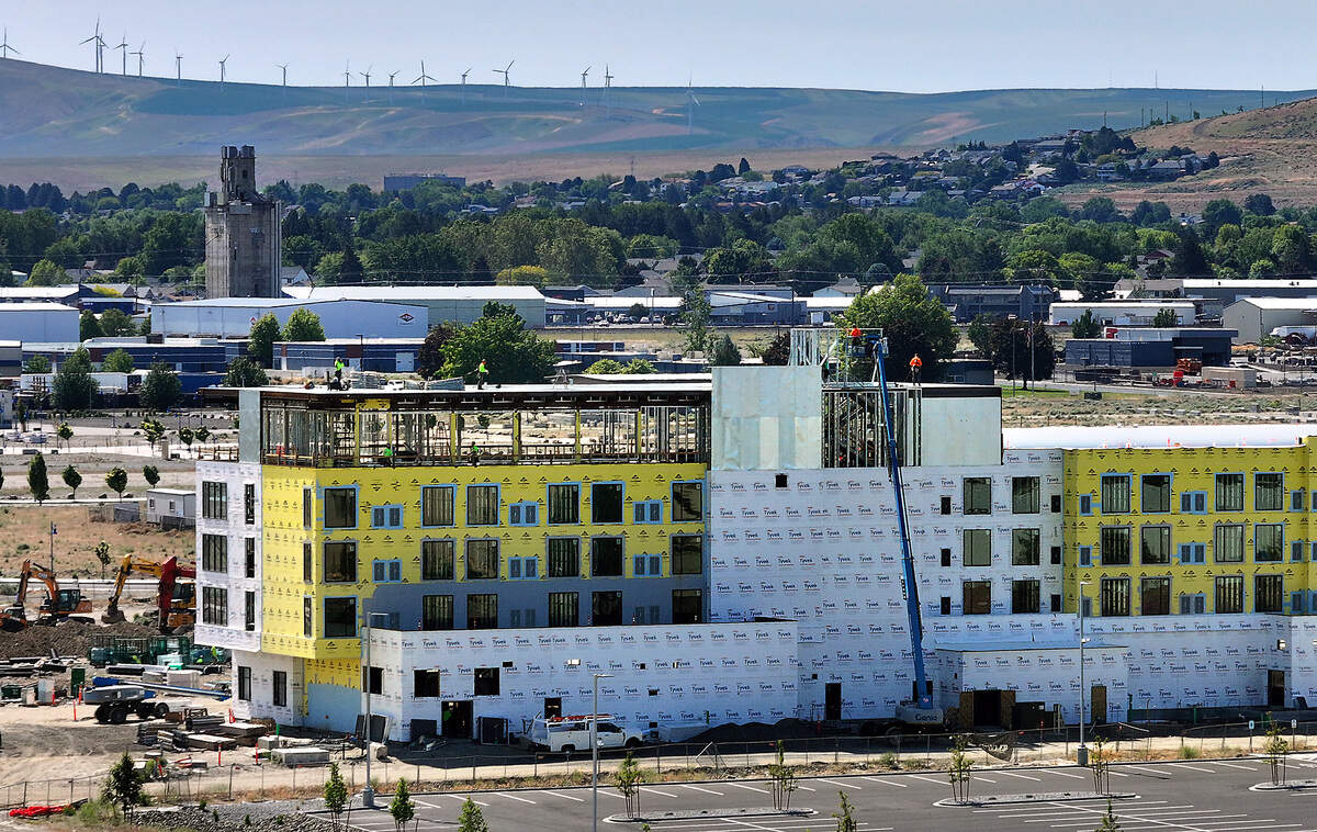 Construction workers use a boom lift to work on the roof of the $47 million five-story AC Marriott Hotel next to the Three Rivers Convention Center campus in Kennewick.
