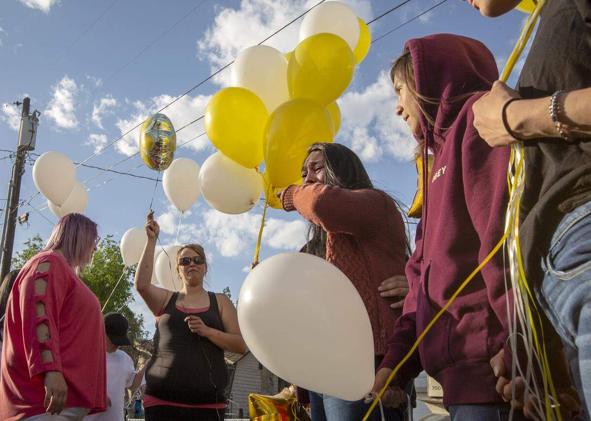Janet Nunez, center, cries as she holds some balloons while surrounded Wednesday by friends and family at a memorial ceremony for her daughter Andrea who was shot and killed Sunday in Kennewick.