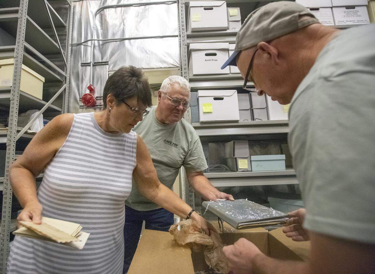 Wyatt and Laura Wineinger, and historian Donald Sorenson, right, take artifacts out of a box on Wednesday at the Hanford History Project office at Washington State University in Richland. The artifacts belonged to Wyatt Wineinger’s father, Day’s Pay bomber pilot Arlys “Duane” Wineinger, and were donated by Wyatt to the Washington State University Tri-Cities Hanford History Project.