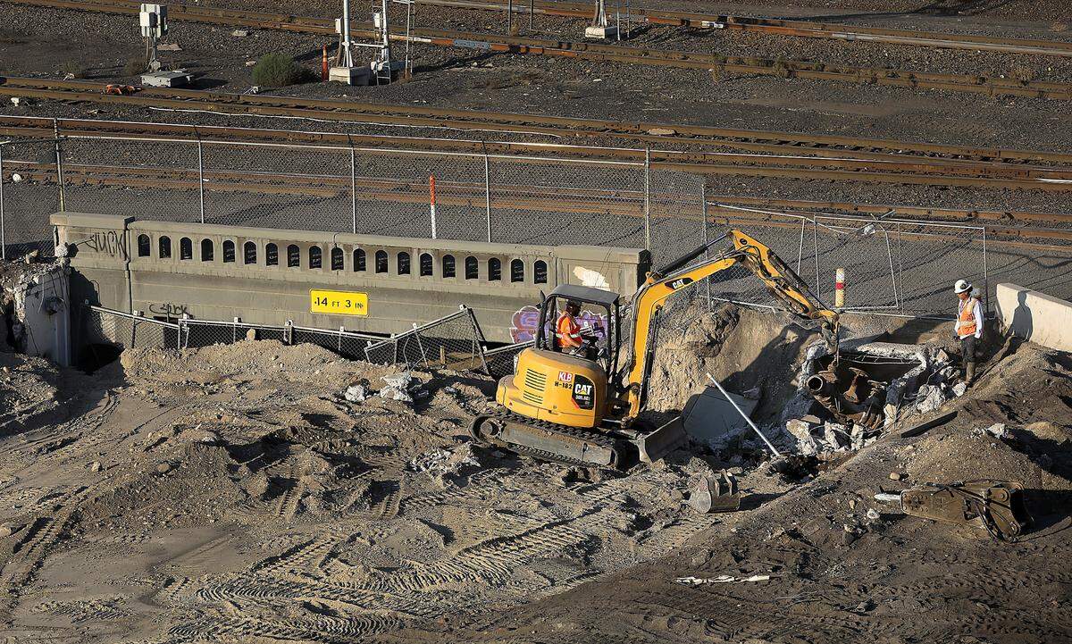 Crews remove a section of old water main pipe near the sealed off underpass as part of the Lewis Street Overpass project in Pasco.