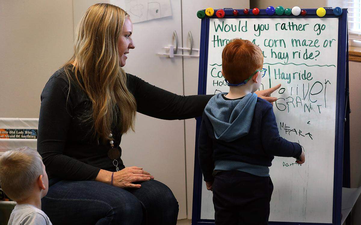 Techer Jana Cannell helps students in the full-time program at Level Up Learning in Kennewick answer a question about their recent trip to a local pumpkin patch.