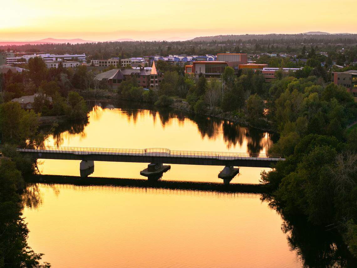 The Spokane River is illuminated with the sunset sky’s reflection.