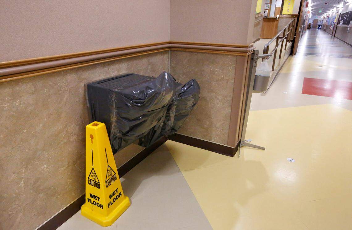 Plastic garbage bags cover the drinking fountains in a hallway at a Pasco elementary school.