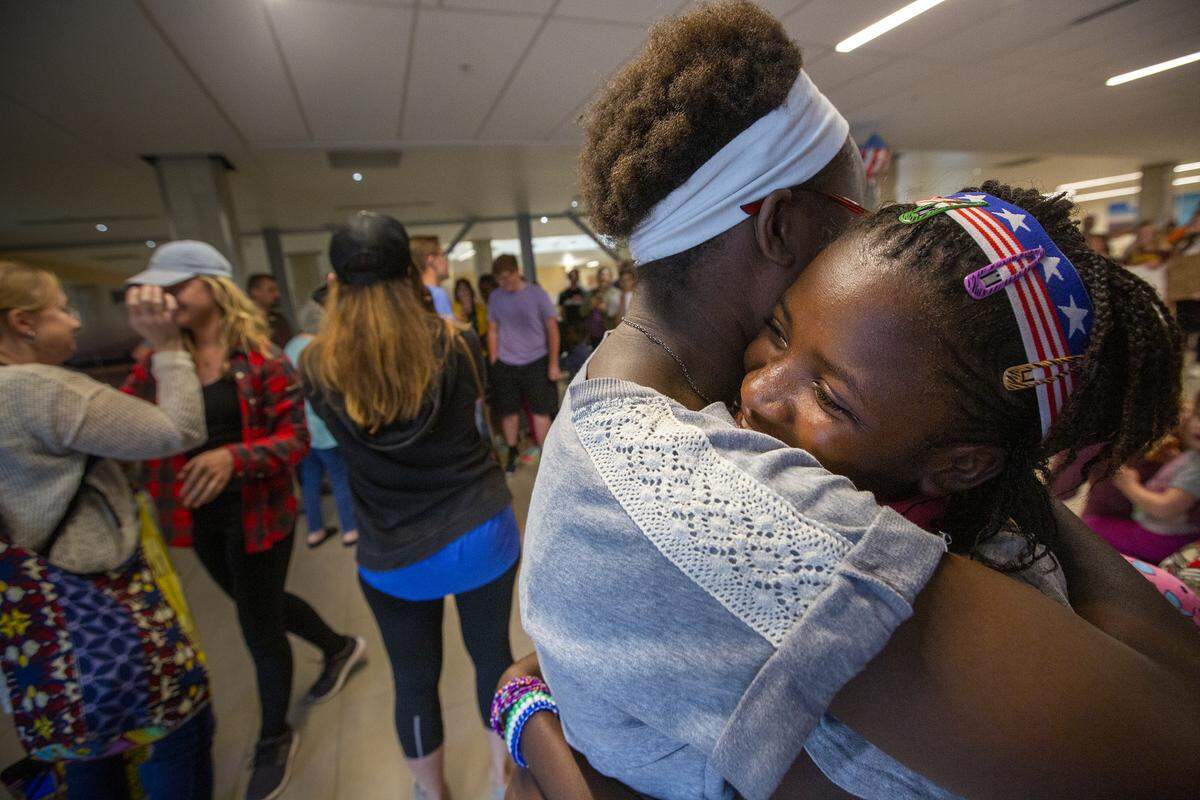 Esther Mailloux, left, embraces Rachel Rhoden inside the Tri-Cities Airport in Pasco. The girls lived together in a Sierre Leone orphanage for four years. Mailloux arrived in the Tri-Cities before the other children.