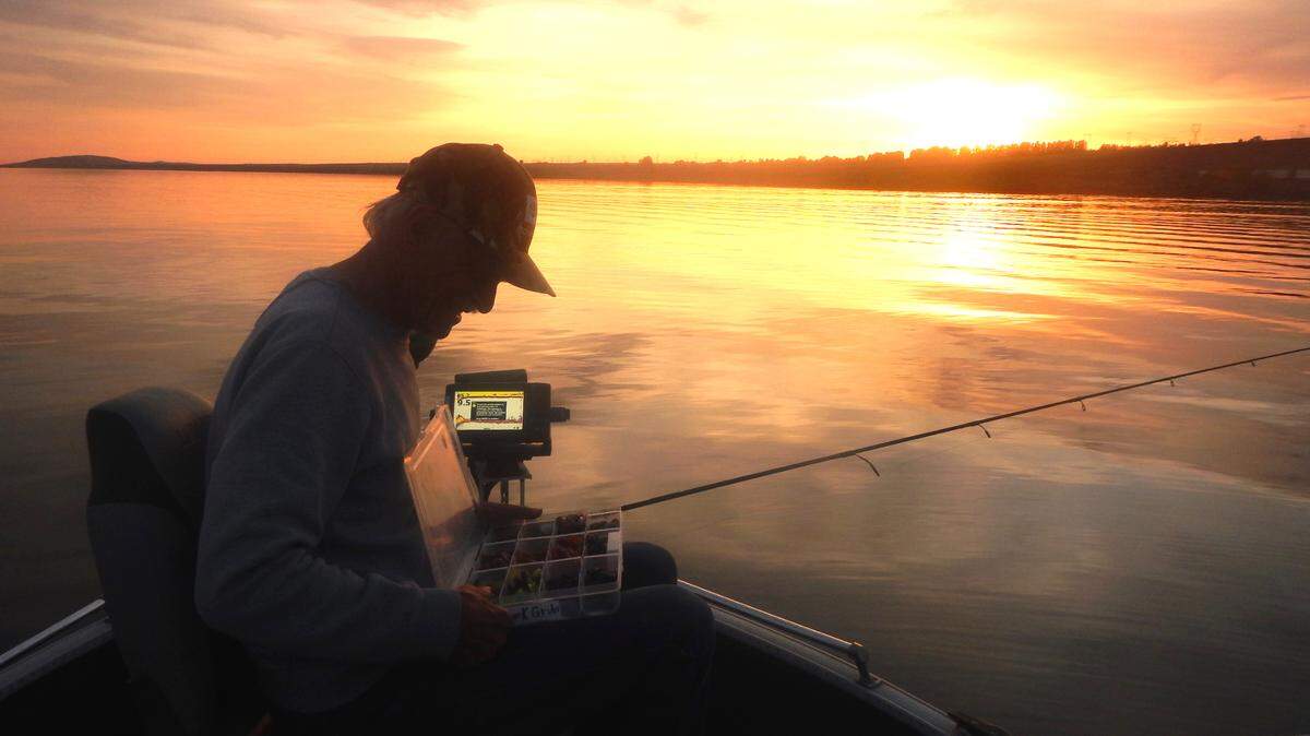 Wayne Heinz sorts through his tackle box for one last cast before the sun goes down.