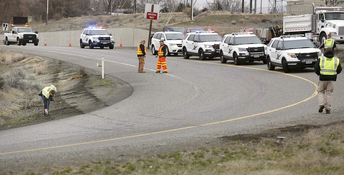 An investigator from the Washington State Patrol documents the scene of Thursday morning’s crash of a fleeing vehicle at the ramp to westbound Interstate 182 from Highway 240 in Richland. The injured driver was briefly trapped in the car that landed upside down off the roadway.
