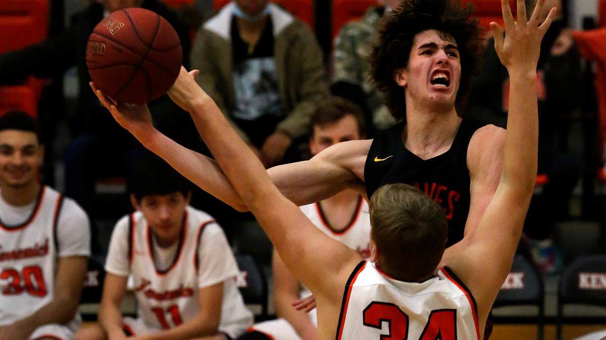 Kamiakin’s Trey Arland draws contact from Kennewick defender Nathan Knapik while attempting a shot during their Jan. 18, 2022 game at Kennewick High School. Kamiakin was 62-55