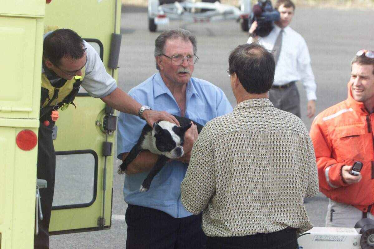 Jim Watts holds Maggie, a damp Boston terrier, after rescuing the dog and her owner from the Columbia River in June 2005. The man's boat had capsized while fishing and left them floating for two hours.