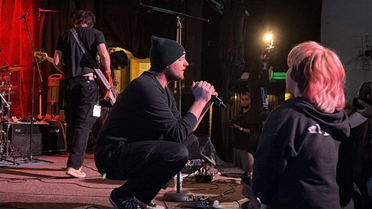 Lead vocalist of A Quiet Life, Logan Turple, crouches on stage while performing at PUNKS WEAR BLXCK at The Uptown Theatre on June 6.