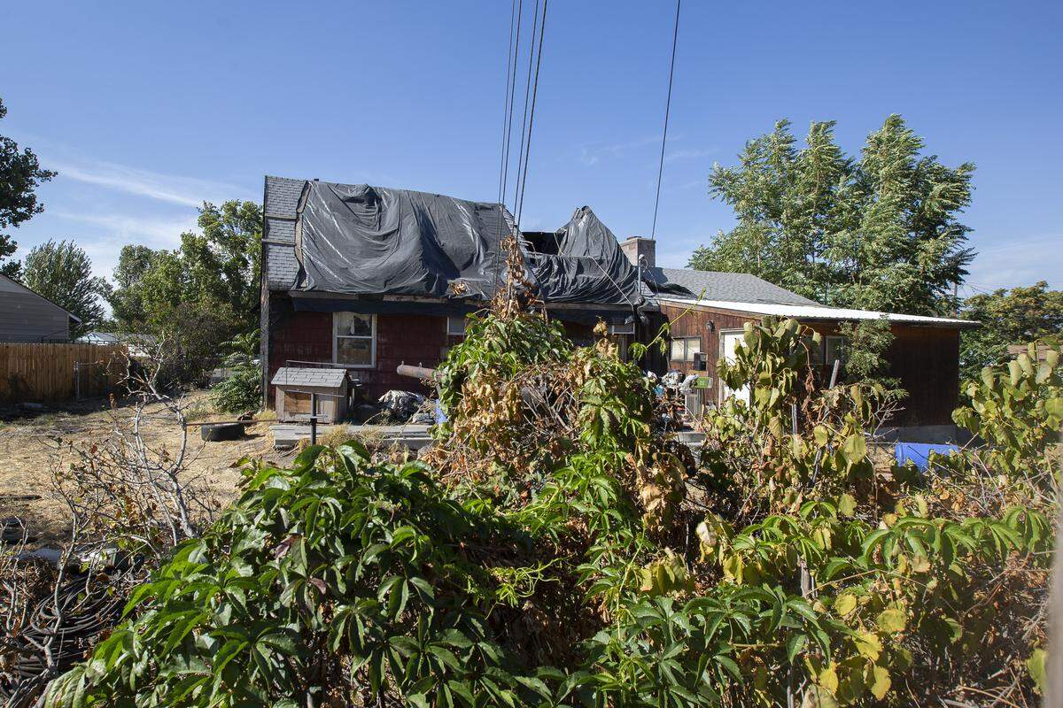 A view of the backyard of an abandon burned home from a neighbor’s yard. It has been a year since this home caught fire and it hasn’t been repaired or demolished.