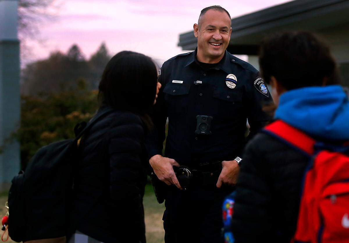 School Resource Officer Richard Sanders, with the Kennewick Police Department, talks with students outside Park Middle School in Kennewick in 2022.