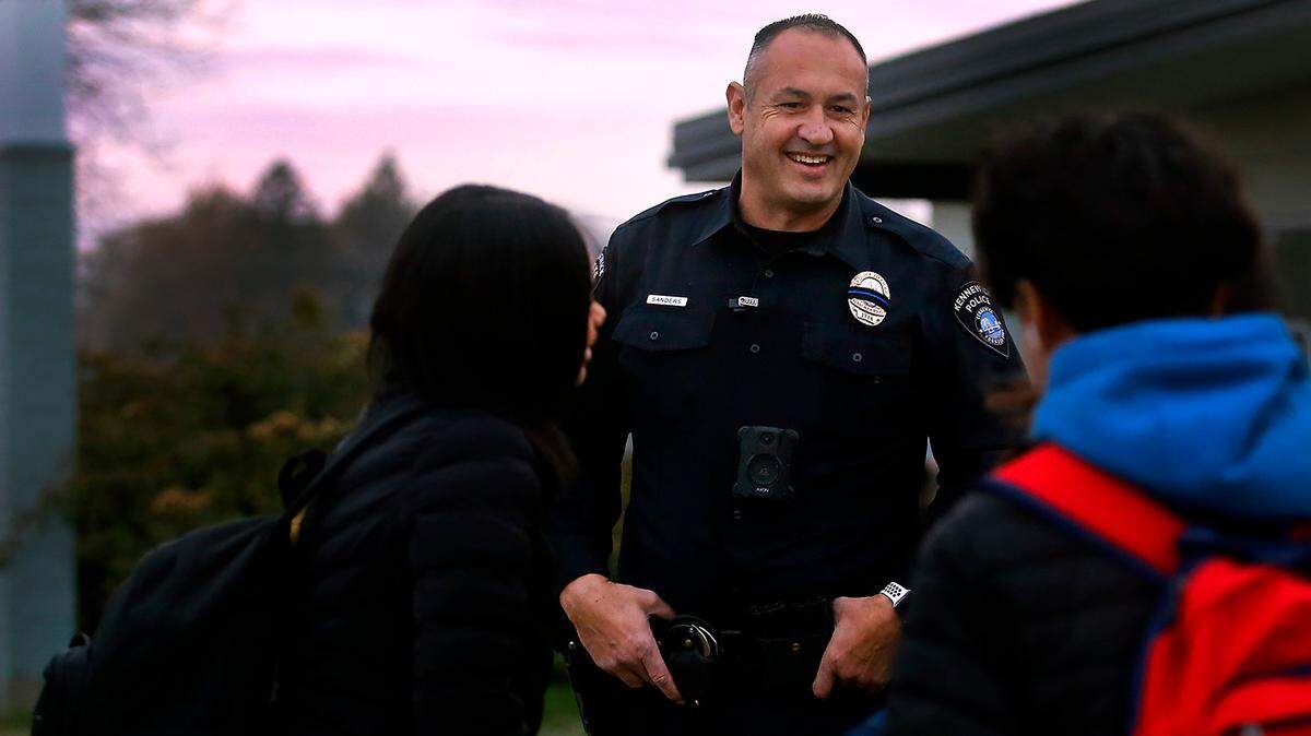 School Resource Officer Richard Sanders, with the Kennewick Police Department, talks with students outside on a recent chilly morning as they arrive for their classes at Park Middle School in Kennewick. Sanders splits his coverage as an SRO at both Park and Horse Heaven Hill Middle schools.