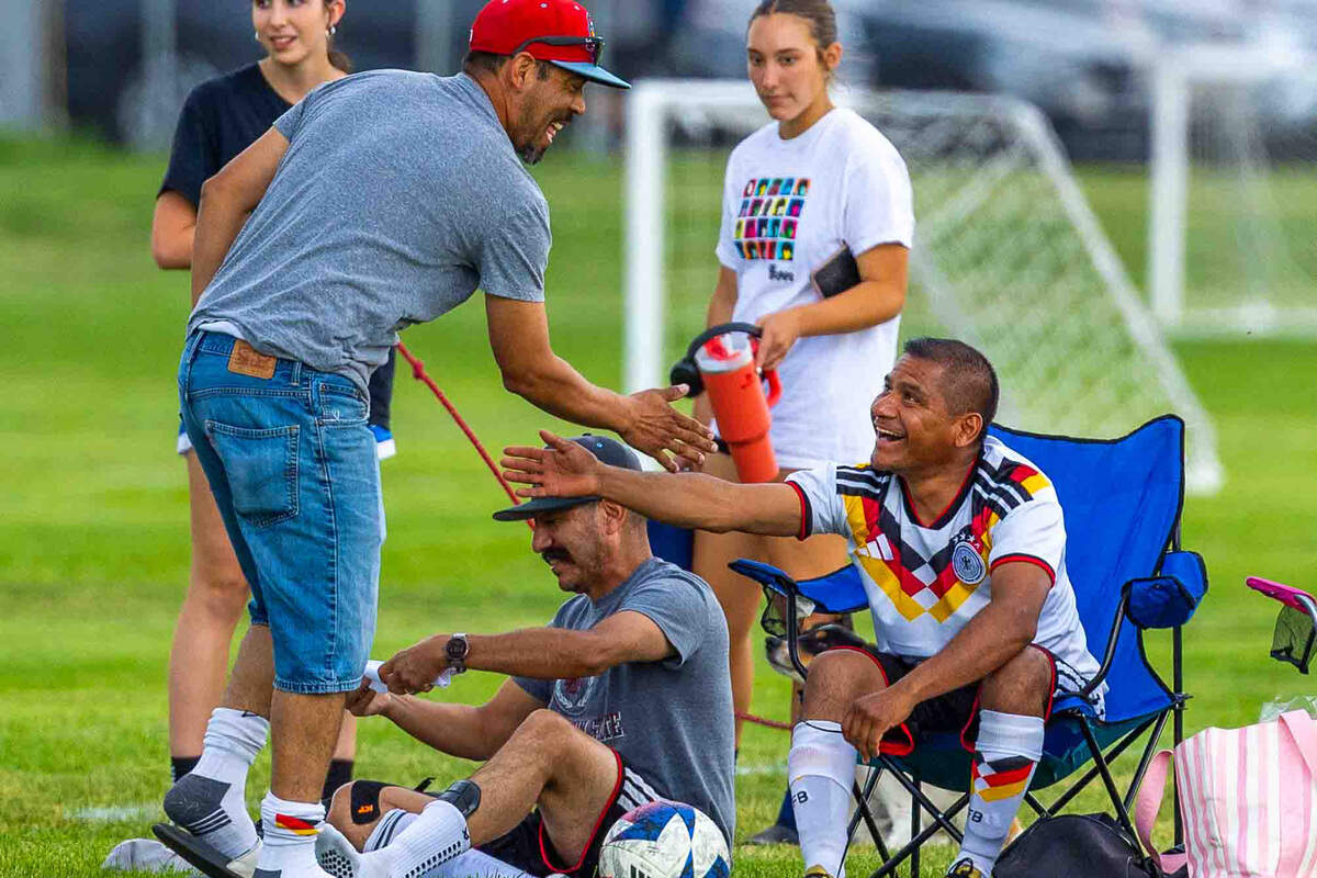 Alfredo Herrera, right, greets a teammate before the start of a La Liga 1020 Division Championship soccer match at the Tri-City Soccer Association Soccer Complex.