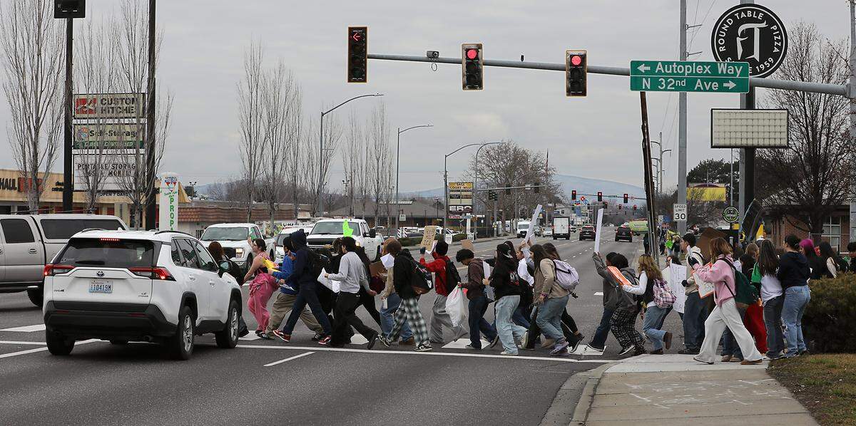 Dozens of teens from Pasco high schools cross West Court Street at North 32nd Avenue in Pasco Friday afternoon during a march to protest ICE and the immigration enforcement.