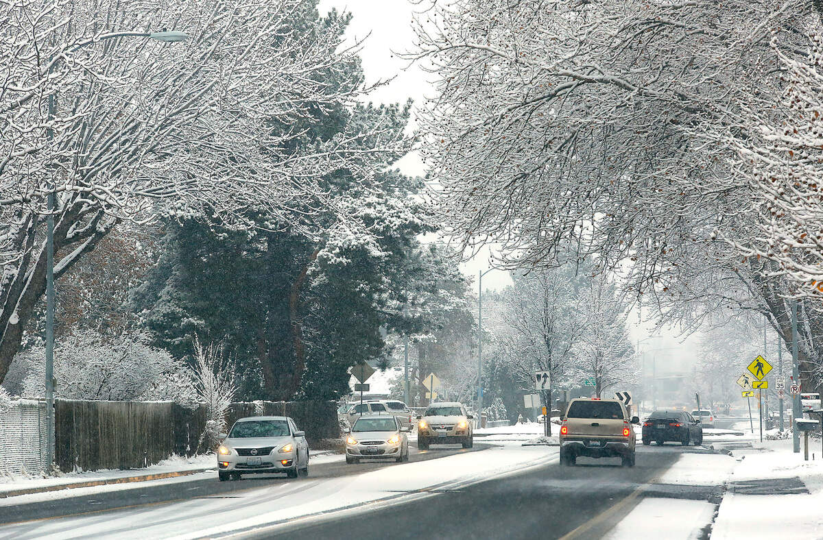 Snow coats the ground and trees creating an appealing winter scene on South Union Street near the Fourth Avenue traffic roundabout early Monday morning in Kennewick.
