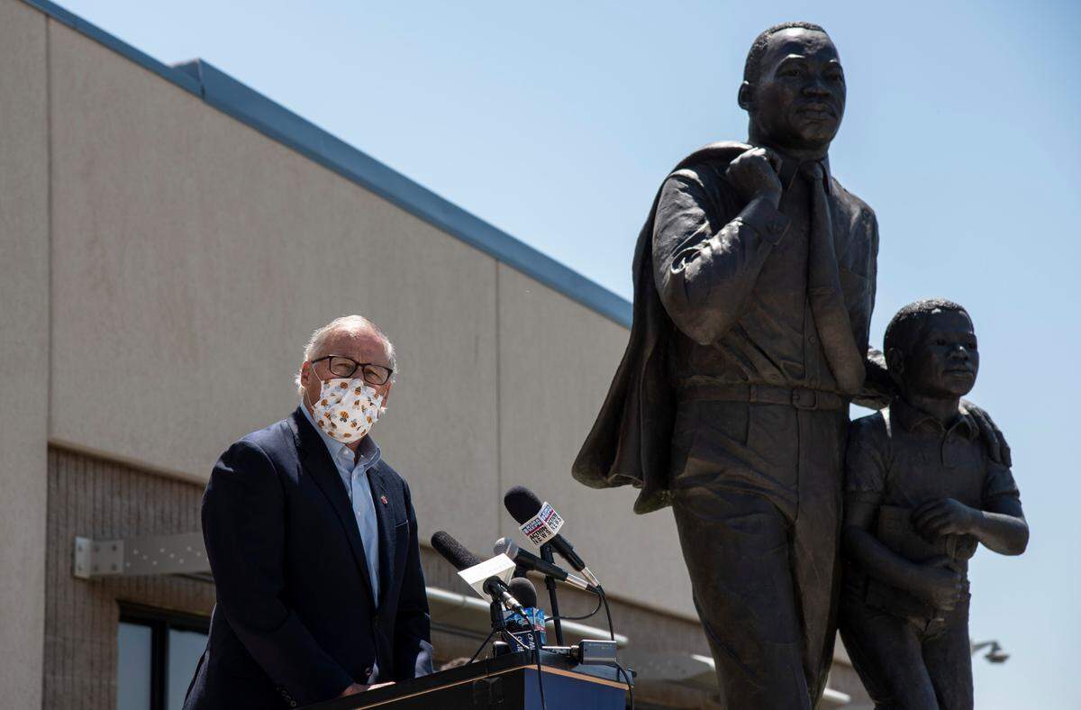 Gov. Jay Inslee started a press briefing outdoors at Columbia Basin College in Pasco Tuesday, standing near a statue of Martin Luther King Jr. The briefing was moved indoors after three protesters began shouting.