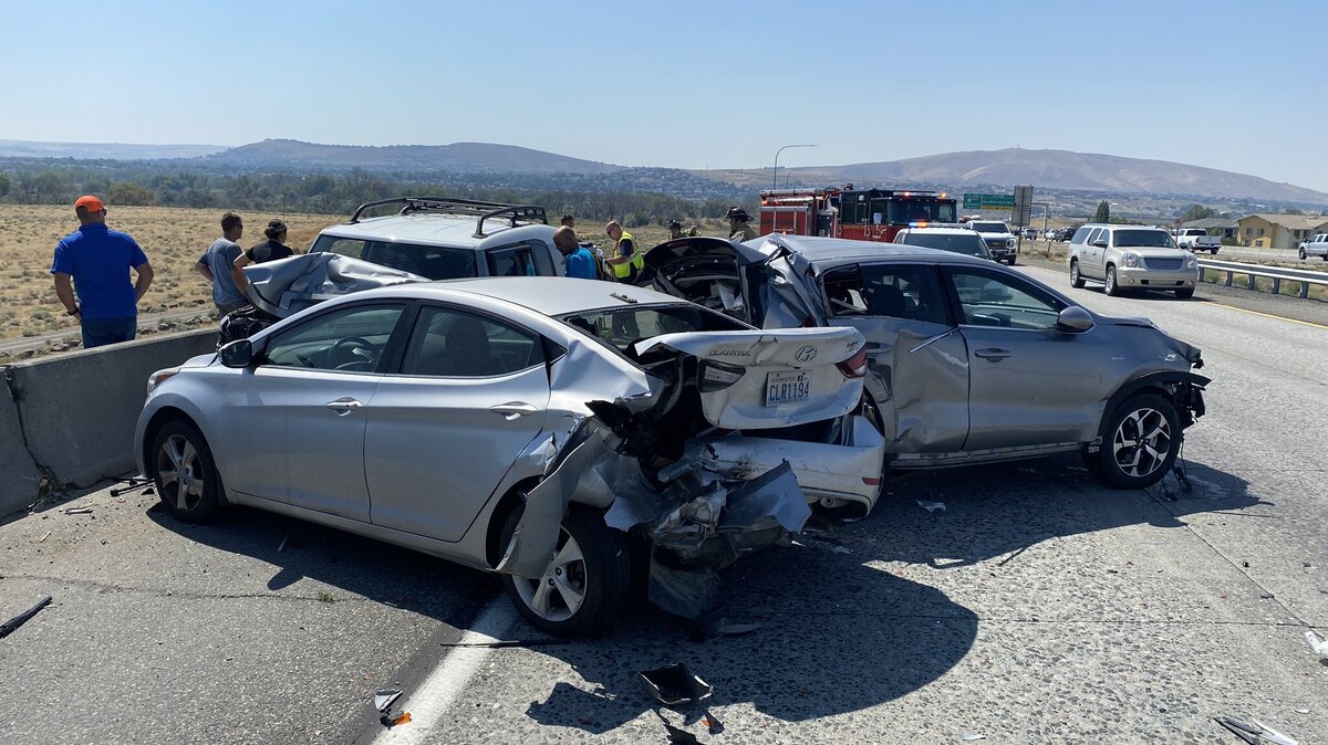 A woman was hurt after being hit by another car while changing a tire on the side of a Tri-Cities highway.
