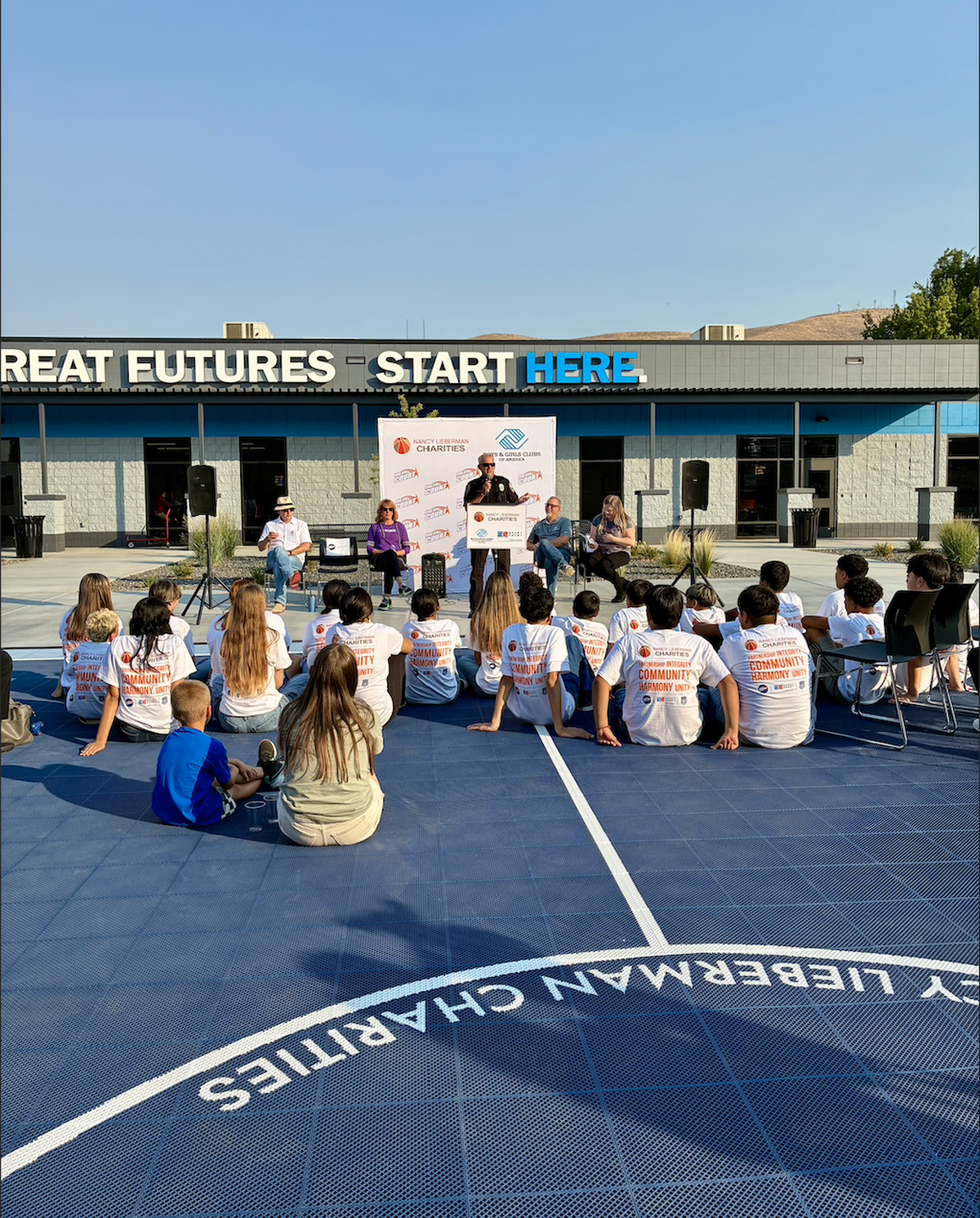 Kids gathered on the brand-new Dream Court at the Prosser Boys & Girls Club listen as Prosser Police Chief John Marcus gives speech.