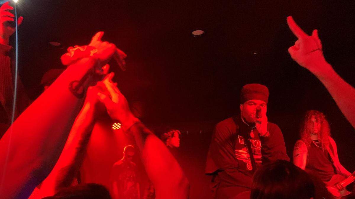 Headlining rapper Topp takes a knee on stage while addressing the crowd at Ray’s Golden Lion Nov. 25, the final stop in Topp’s Life’s Crazy Tour. His set was accompanied by AFFILI8D lead guitarist, Collin Jay (right).
