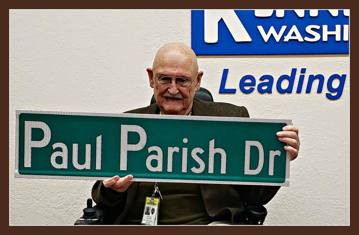 Paul Parish, who has served on the Kennewick City Council for 24 years, holds a street sign showing the new name of Columbia Park Trail at his last council meeting Tuesday before retiring.