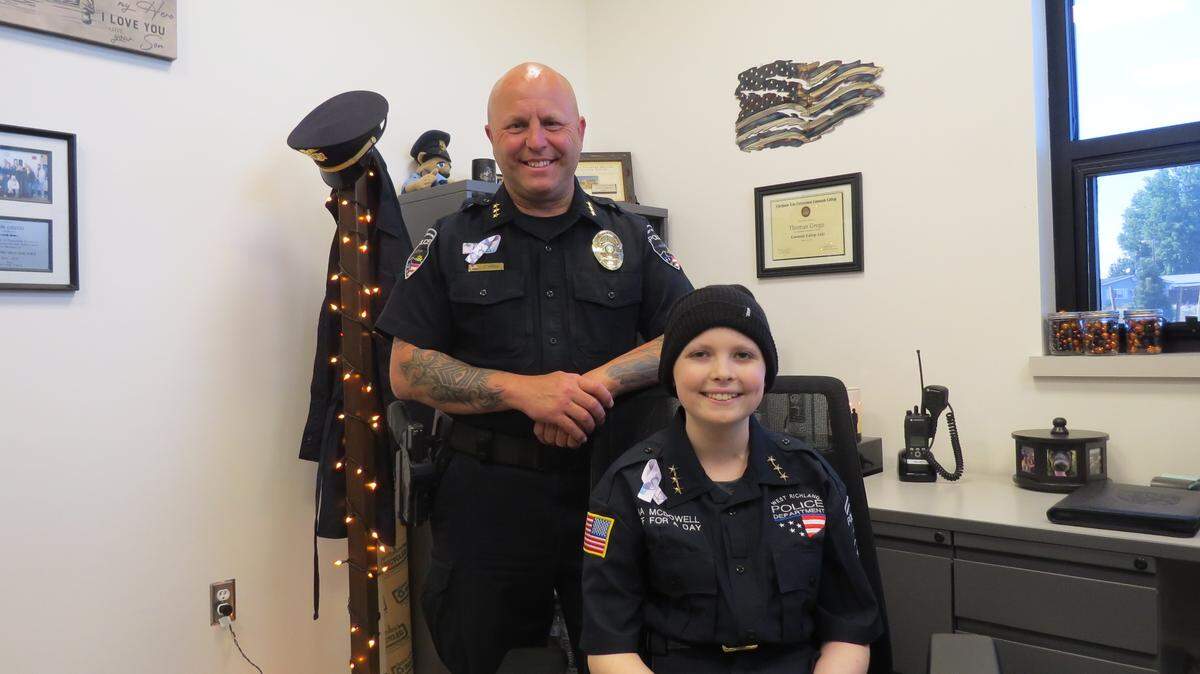 West Richland Chief Thomas Grego poses in 2022 with the city’s Chief for a Day, Lana McDowell, then 13.