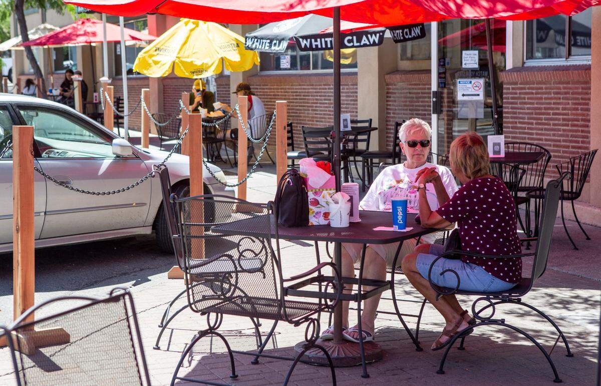 Patrons sit on the patio area outside the Sports Page Bar & Grill in downtown Kennewick. Tri-Cities restaurants and bars are making changes, such as increased outdoor seating, to accommodate coronavirus regulations.