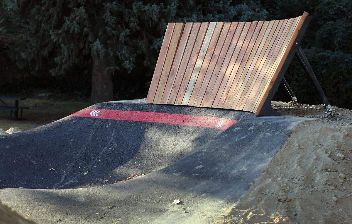 An angled wood plank wall is braced at the top of a hill at  the bicycle pump track being install at Vancouver Park in Kennewick. 